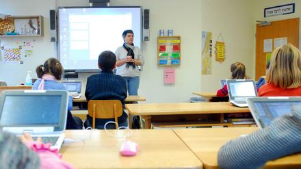 Schüler in einer Berliner Grundschule arbeiten im Klassenzimmer an Laptops.