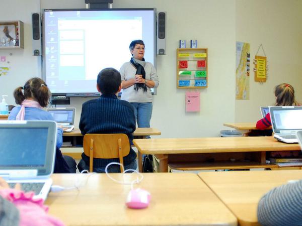 Schüler in einer Berliner Grundschule arbeiten im Klassenzimmer an Laptops.