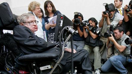 Stephen Hawking bei einer Pressekonferenz, Fotografen richten ihre Kameras auf ihn.