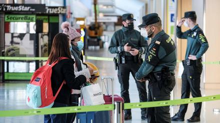 Ratlose Reisende sprechen am Flughafen von Ibiza mit einem Beamten.