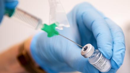 Eine Klinik-Mitarbeiterin zieht den Covid-19 Impfstoff von Biontech/Pfizer für eine Impfung auf eine Spritze. 