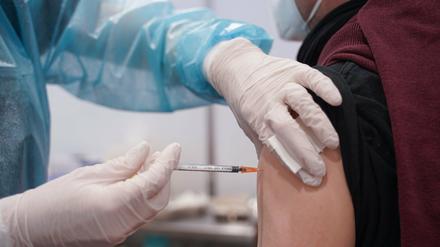 Ein Mann wird mit einer Booster-Dosis eines Corona-Impfstoffs gegen das Coronavirus geimpft. 