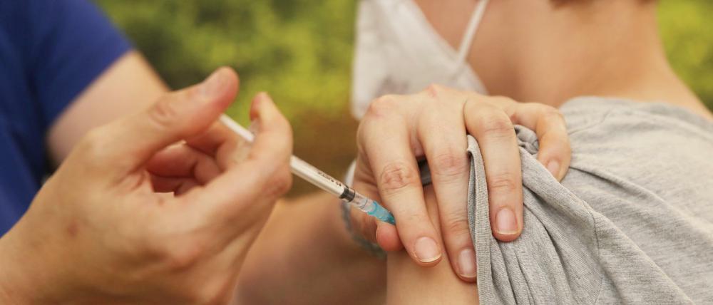 Eine Kinderärztin impft einen Jungen mit dem Corona-Impfstoff Comirnaty von Biontech-Pfizer.