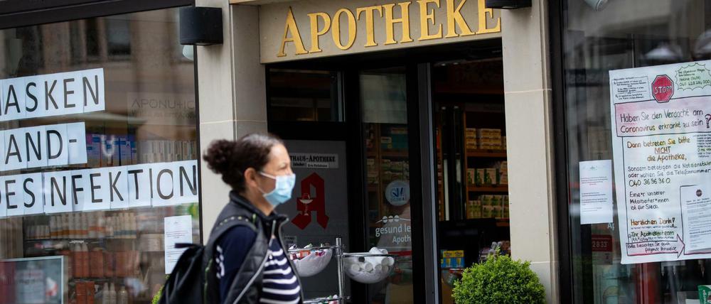 Zettel mit der Aufschrift "Masken" und "Hand-Desinfektion" hängen im Schaufenster einer Apotheke in der Hamburger Innenstadt.