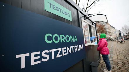 Eine Frau steht an einem Corona-Testzentrum
