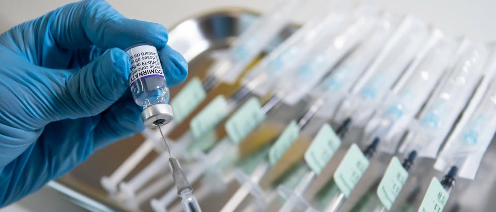 Ein Mitarbeiter bereitet eine Spritze mit dem Impfstoff von Biontech/Pfizer gegen das Coronavirus vor. 