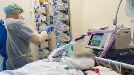 Ein Krankenpfleger versorgt einen schwer an Corona erkrankten Patienten auf der Intensivstation von einem Krankenhaus.