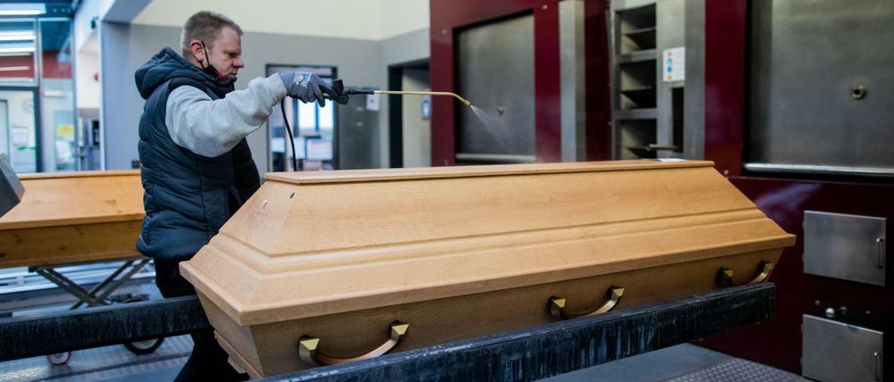 In einem Krematorium in Dülmen wird ein Sarg zur Einäscherung vorbereitet.