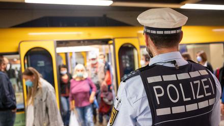 Polizeibeamte kontrollieren an einer Haltestelle im öffentlichen Nahverkehr die Einhaltung der Maskenpflicht