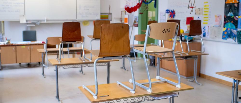 In einem leeren Klassenraum sind Stühle auf die Tische gestellt worden.