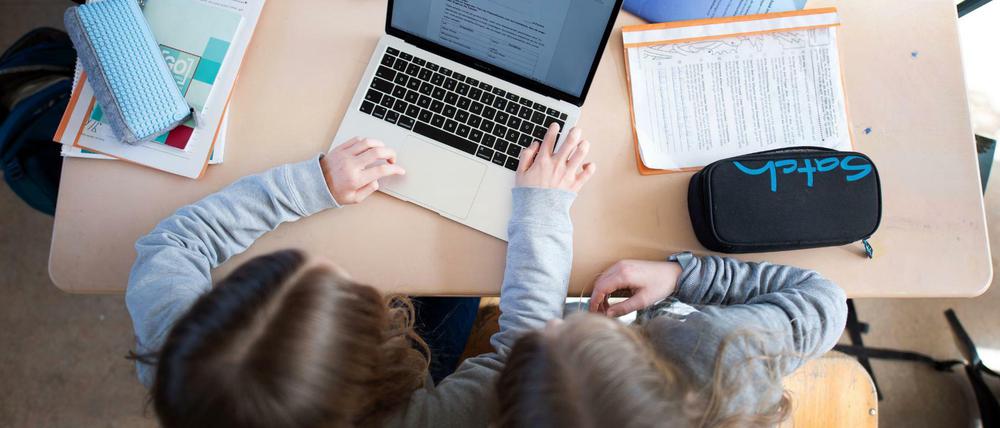 Schüler einer fünften Klasse eines Gymnasiums benutzen im Unterricht einen Laptop