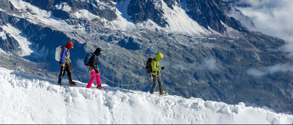 Drei Bergsteiger auf dem schneebedeckten Kamm des Mont Blanc. 