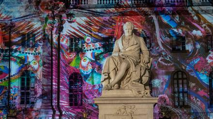 Eine Statue Alexander von Humboldts vor dem Hauptgebäude der Humboldt-Uni - mit farbiger Projektion beim Festival of Lights.