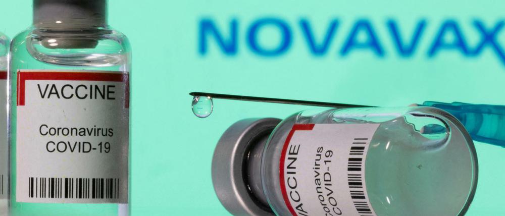 Die Illustration zeigt Impfstoffe und einen Novavax-Schriftzug.