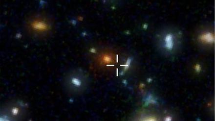 Ganz weit draußen. Das Bild zeigt einen Ausschnitt aus dem Hubble Deep Field mit vielen, weit entfernten Galaxien. Die Submillimeter-Galaxie HDF 850.1 befindet sich an der markierten Stelle. Im optischen Bereich ist sie allerdings nicht sichtbar. Sie lässt sich nur mit Radioteleskopen nachweisen.