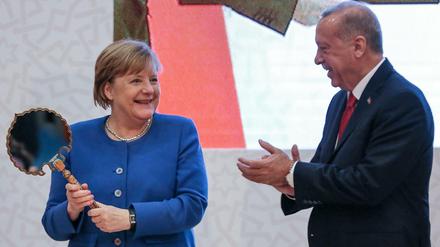 Staatspräsident Erdogan übergibt Kanzlerin Merkel als Geschenk einen antiken Spiegel.