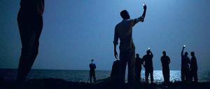 Auf Kontaktsuche: Afrikanische Flüchtlinge versuchen am Strand von Dschibuti ein Handysignal zu empfangen, um ihre Verwandten in der Heimat zu erreichen. 2014 erhielt der Fotograf John Stanmeyer für diese Aufnahme den renommierten World Press Photo Award. 