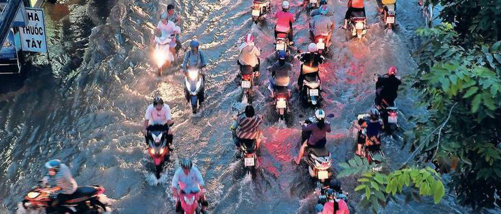 Auch zum Klimawandel wird an der Urania informiert. Im Bild Menschen 2016 in den überfluteten Straßen von Ho-Chi-Minh-Stadt.