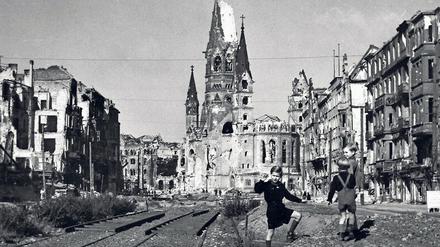 Mahnmal. Vor der Ruine der Kaiser-Wilhelm-Gedächtniskirche spielen Kinder im Nachkriegs-Berlin auf der zerstörten Tauentziehnstraße.