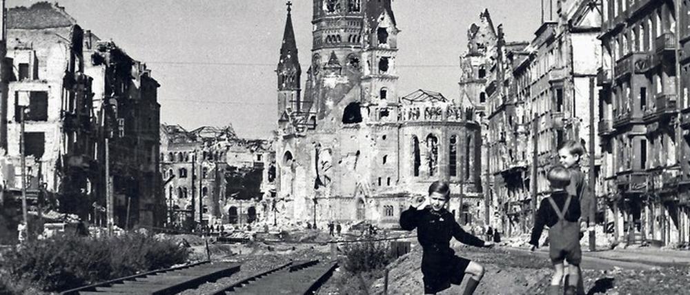 Mahnmal. Vor der Ruine der Kaiser-Wilhelm-Gedächtniskirche spielen Kinder im Nachkriegs-Berlin auf der zerstörten Tauentziehnstraße.