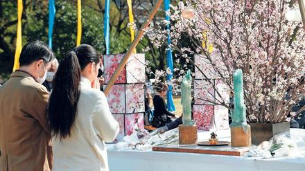 Stilles Gebet. Zahlreiche Menschen versammelten sich am 11. März 2020 in einer Gedenkstätte im Hibiya Park von Tokio.