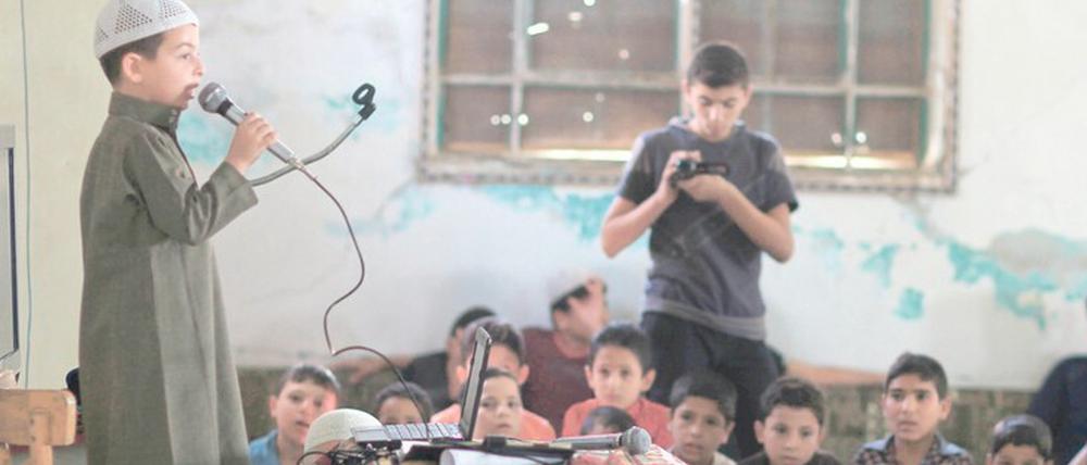 Hochkonzentriert. Ein Junge rezitiert den Koran bei einem Lernwettbewerb. Das Foto entstand 2016 in einem Vorort von Damaskus in Syrien.