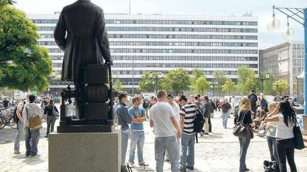 Auf dem TU-Campus. Studierende vor dem Hauptgebäude auf der Straße des 17. Juni. Im Vordergrund steht eine Siemens-Statue.