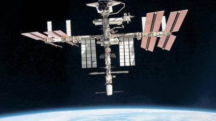 Über den Wolken. Die Raumstation (hier eine Aufnahme vom Mai 2011) rast mit 28 000 Kilometern pro Stunde um die Erde. Derzeit sind drei Russen, zwei Amerikaner und ein Japaner an Bord, die bis zum Jahresende zurückkehren müssen. Ob bis dahin neue Astronauten zur Station fliegen, ist unsicher. 