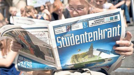 Gut studiert. Einige niederländische Unis bieten sogar deutsche Studiengänge an. Hier liest eine Studentin aber eine holländische „Studentenkrant“, also eine Studentenzeitung. 