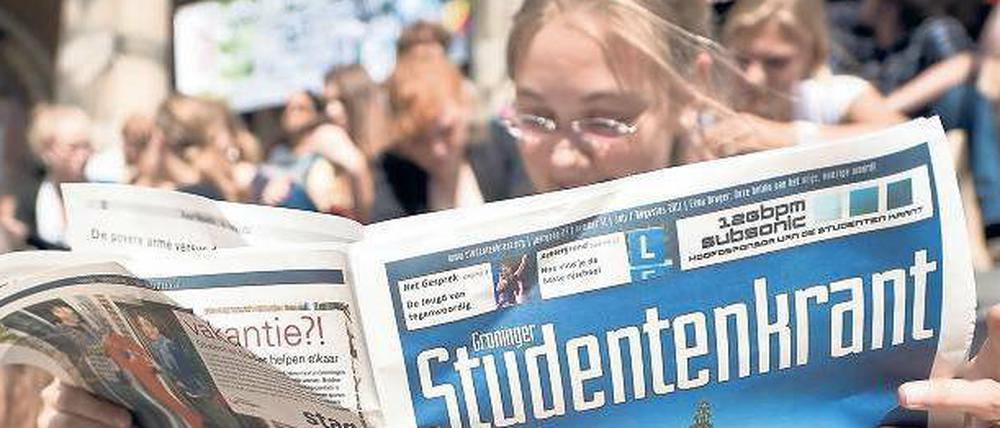 Gut studiert. Einige niederländische Unis bieten sogar deutsche Studiengänge an. Hier liest eine Studentin aber eine holländische „Studentenkrant“, also eine Studentenzeitung. 