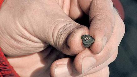 Himmlischer Krümel. Dies ist vermutlich ein Bruchstück des Meteoriten, der am Freitag nahe der Stadt Tscheljabinsk niedergegangen ist. Insgesamt wurden 53 Trümmer gefunden. 