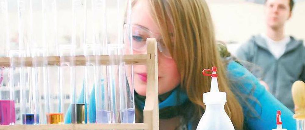 Eine Schülerin arbeitet im Chemie-Labor mit Reagenzgläsern und Flüssigkeiten.