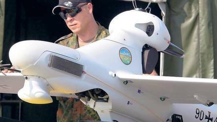 Ein Bundeswehrsoldat führt auf einer Luftfahrtausstellung eine Drohne vor.