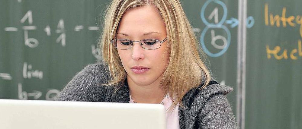 Eine junge Wissenschaftlerin sitzt am Laptop und schreibt.