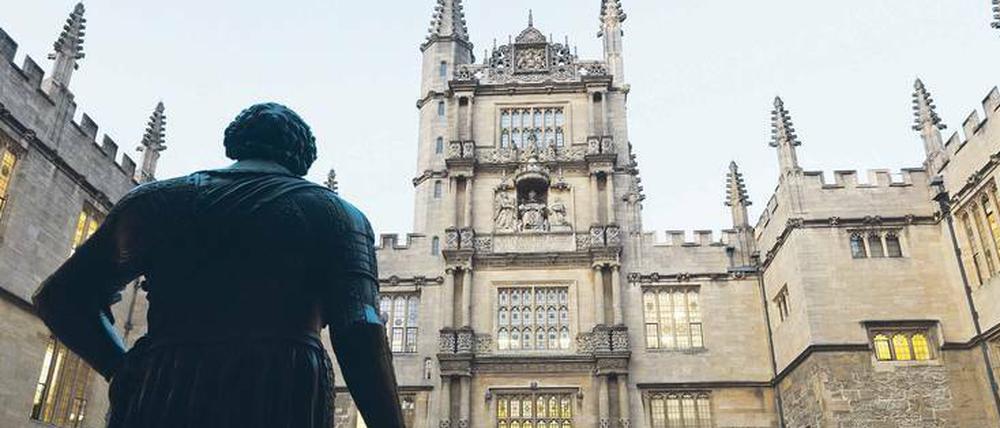 Eine Skulptur steht vor einem historischen Universitätsgebäude in England.