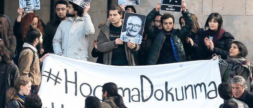 Studenten und Professoren halten vor einem Universitätsgebäude Transparente mit Parolen in türkischer Sprache hoch.