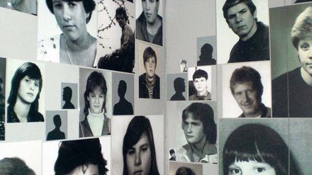 Fotos von Kindern und Jugendlichen hängen in einer Ausstellung an einer Wand.