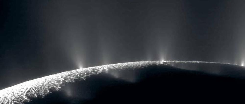 Sprühend vor Leben? Fontänen zeugen von einem Ozean unter dem Eis des Saturnmonds Enceladus. Irdische Bakterien könnten dort überleben.