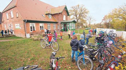Kinder spielen vor einer privaten Grundschule in Mecklenburg-Vorpommern im Garten.