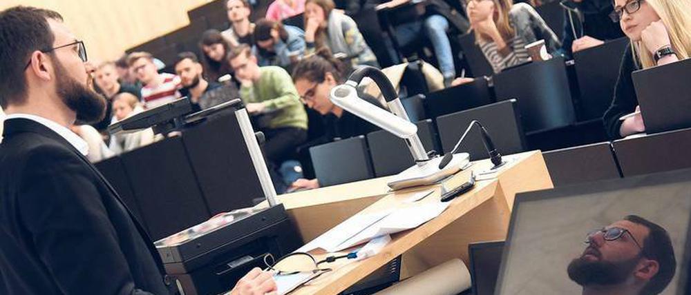 Ein junger Hochschullehrer steht in einem Hörsaal der Universität Halle vor Studierenden.