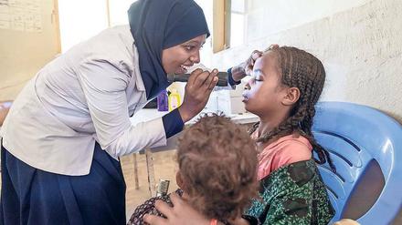 Die Ophtalmic Nurse Sofiya Mohammed untersucht zwei Mädchen.
