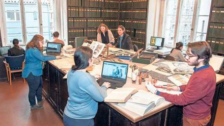 Studierende arbeiten am großen Tisch der Fotothek in der Winckelmann-Bibliothek.