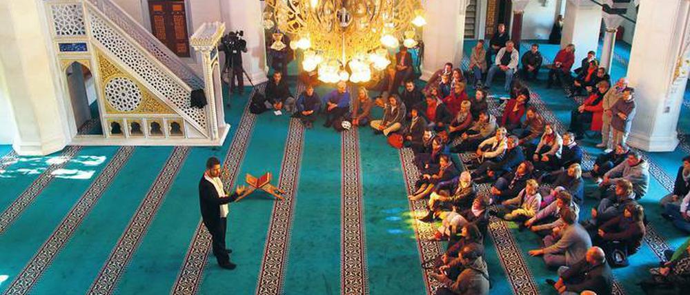 Am Tag der offenen Moscheen 2015 in der Berliner Sehitlik-Moschee spricht ein Vertreter der Moschee mit Besuchern.