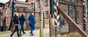 Schülerinnen gehen durch das Haupttor des ehemaligen Vernichtungslagers Auschwitz.