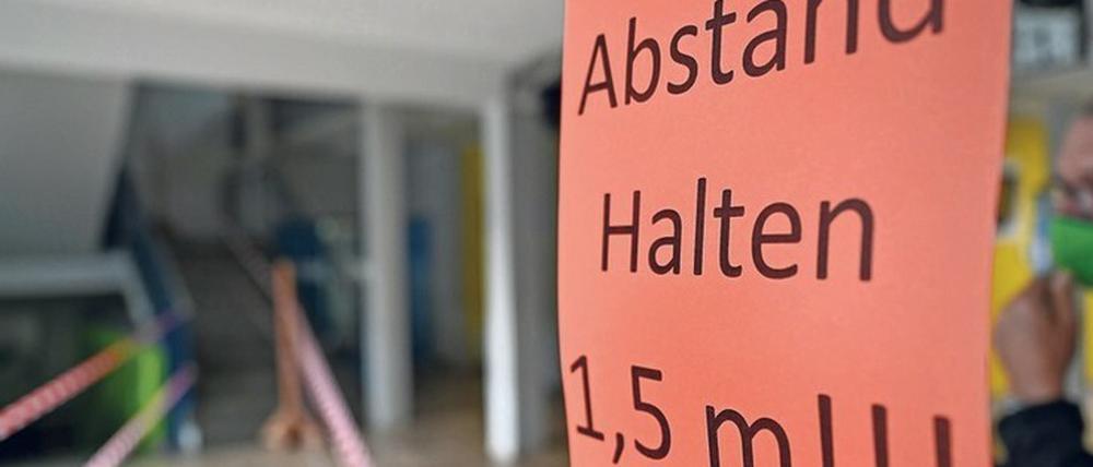 In einer Schule fordert ein Schild Schüler und Lehrkräfte dazu auf, 1,5 Meter Abstand zu halten. Das Verb halten ist mit einem großen H geschrieben.