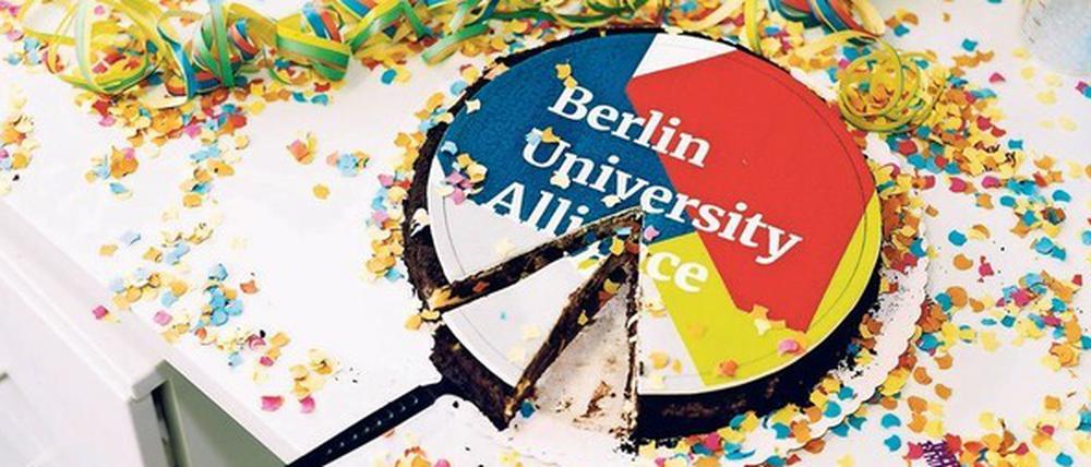 Eine Schokoladentorte, die in den Farben Weiß, Blau und Gelb und mit dem Schriftzug Berlin University Alliance dekoriert ist.