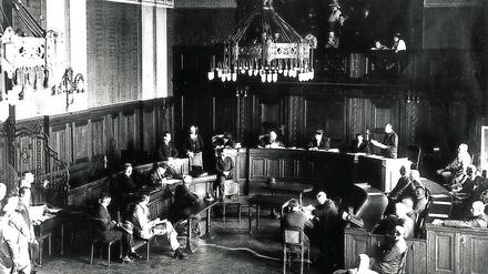 Gerichtsverhandlung in einem historischen Gerichtssaal.