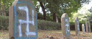 Grabsteine auf einem jüdischen Friedhof sind mit Hakenkreuzsymbolen beschmiert.