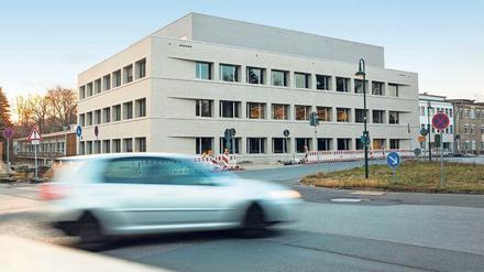 Ein moderner Forschungsbau steht auf einem Campus in Berlin, im Vordergrund fährt ein Auto vorbei.