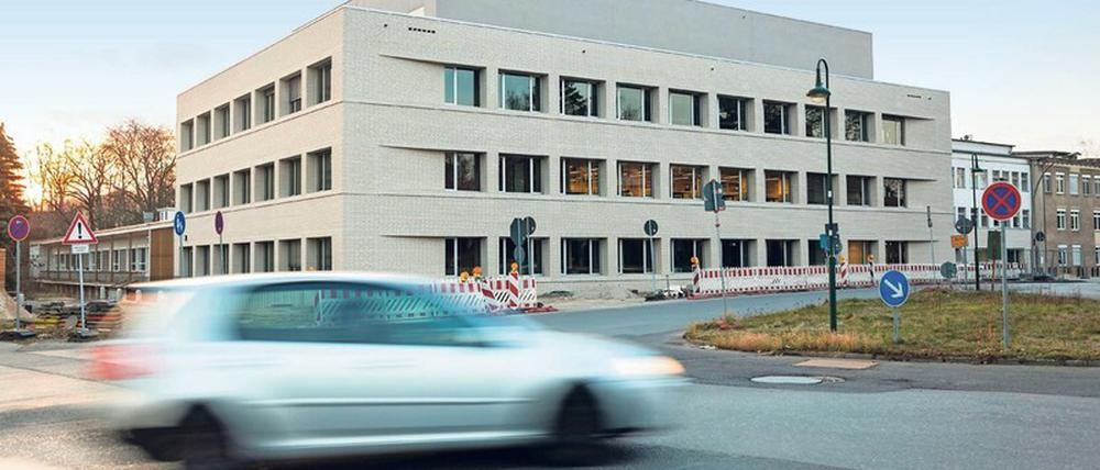 Ein moderner Forschungsbau steht auf einem Campus in Berlin, im Vordergrund fährt ein Auto vorbei.